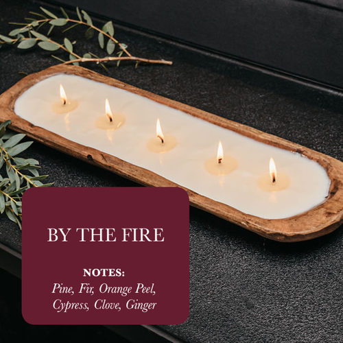 Dough bowl soy candle with light-colored wax and five lit wicks in rustic wooden tray